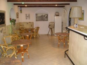restauracja ze stołami i krzesłami w pokoju w obiekcie L'ilot Fleuri w mieście Le Lavandou