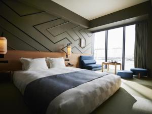 a bedroom with a large bed and a blue chair at Asakusa View Hotel Annex Rokku in Tokyo