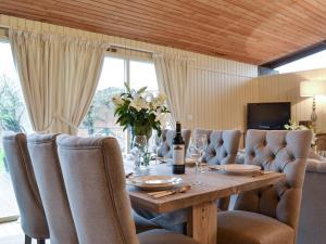 a dining room table with chairs and a bottle of wine at Pampita Lodge in Beverley