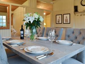 een tafel met borden en glazen en een vaas met bloemen bij Pampita Lodge in Beverley