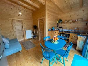 a kitchen and dining room with a blue table and chairs at The lodge corfu in Mesongi