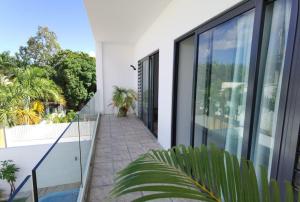 un balcón de una casa con paredes de cristal en villa de la lumiere, en Trou aux Biches