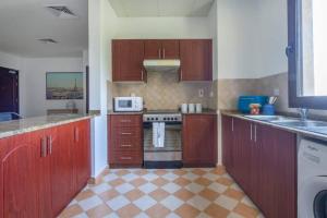 a kitchen with wooden cabinets and a stove top oven at Cool and spacious apartment in fabulous location in Dubai