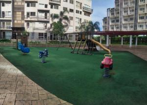 a playground with play equipment on a green lawn at Monteluce Staycation in Silang
