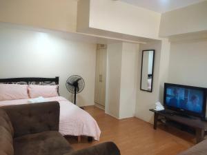a bedroom with a bed and a flat screen tv at Monteluce Staycation in Silang