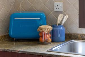 a kitchen counter with a blue toaster next to a sink at Cool and spacious apartment in fabulous location in Dubai
