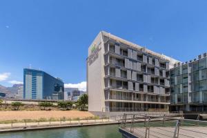 un edificio alto junto a un cuerpo de agua en Luxury 2 bed apart 515 Harbour Bridge, Dockrail Road, Foreshore, Cape Town, 8001, en Ciudad del Cabo