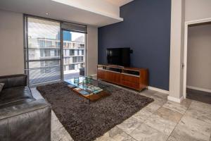 sala de estar con sofá y TV de pantalla plana en Luxury 2 bed apart 515 Harbour Bridge, Dockrail Road, Foreshore, Cape Town, 8001, en Ciudad del Cabo