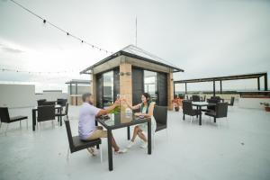 un homme et une femme assis à une table sur un patio dans l'établissement Seeya Hotel, à Tubigon