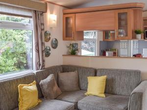 uma sala de estar com um sofá com almofadas amarelas em Tranquillity Lodge em Annbank