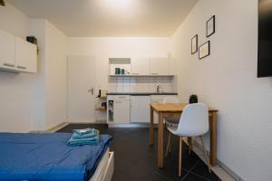 um quarto com uma cama, uma mesa e uma cozinha em Gemütliches Studio im Stadtzentrum em Biel