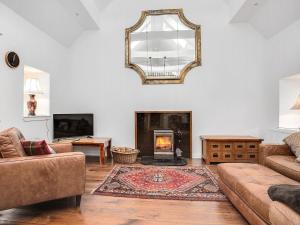 a living room with a fireplace and a mirror at The Old Barn - Uk40948 in Auchtermuchty