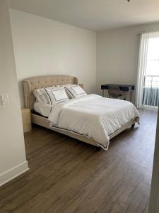 a bedroom with a large bed with white sheets and pillows at Villa Marina - Modern & Immaculate, Spacious, Gated Condo with Fireplace Pool, Gym, 2 Master Bedrooms in Los Angeles
