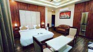 una camera d'albergo con letto, sedia e tavolo di V SQUARE AIRPORT HOTEL a Lucknow