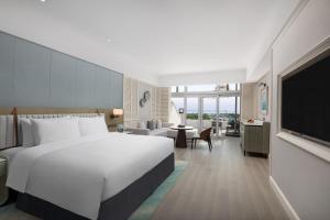 een hotelkamer met een groot bed en een televisie bij Xiamen International Seaside Hotel-Free Welcome Fruit& Mini Bar in Xiamen