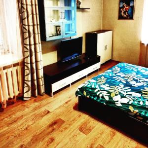 1 dormitorio con 1 cama y TV de pantalla plana en Admiral Home en Mykolaiv