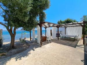 a wooden pergola with a bench and a table at Seaside apartments Brist in Tkon