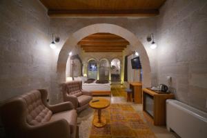 ein Hotelzimmer mit einem Bett, einer Couch und einem Tisch in der Unterkunft Cappadocia Secret Hill Cave Suites in Goreme