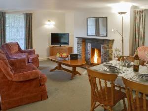 - un salon avec une cheminée, une table et des chaises dans l'établissement Grannys Cottage, à Lostwithiel