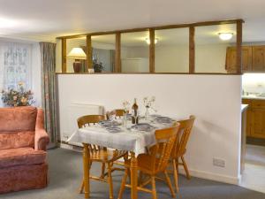 - une salle à manger avec une table, des chaises et un miroir dans l'établissement Grannys Cottage, à Lostwithiel