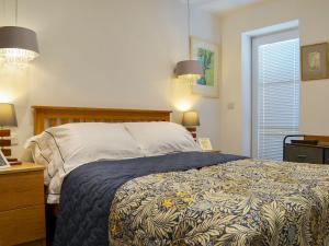 Hurst House في سانت بييز: غرفة نوم بسرير ومصباحين ونافذة