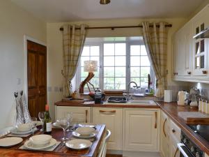 una cocina con una mesa con platos y vasos. en Broomhouse Lodge, en Edrom