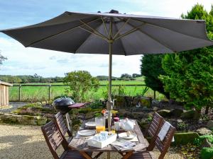 a table with an umbrella in a garden at Broomhouse Lodge in Edrom