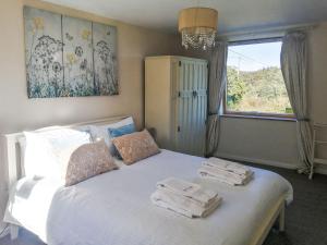 a bedroom with a white bed with towels on it at Broomhouse Lodge in Edrom