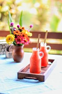 dos tazas en una bandeja con flores en una mesa en Cute Eco Cottage Near 7 Waterfalls, en Singaraja