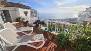 balkon z 2 krzesłami i widokiem na ocean w obiekcie Penthouse Vistamar Torrox Costa w mieście Torrox Costa