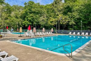 a large swimming pool with chairs and umbrellas at Gas Grill, Lake Access Scenic Poconos Retreat! in East Stroudsburg