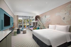 Xiamen International Seaside Hotel-Free Welcome Fruit& Mini Bar في شيامن: غرفة نوم بسرير كبير وغرفة اطفال