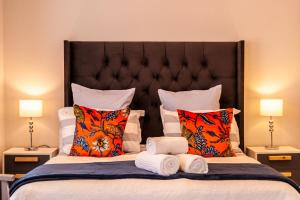 - une chambre avec un grand lit et des serviettes dans l'établissement Tortelduif Cottage, à Stellenbosch