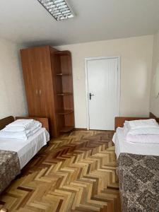 Habitación con 2 camas y puerta blanca en Zarea Hotel, en Chişinău