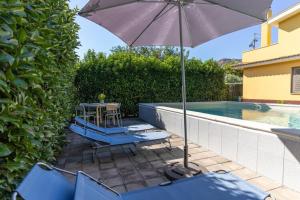 een patio met een tafel en stoelen en een parasol bij Holiday home in Francavilla di Sicilia in Francavilla di Sicilia
