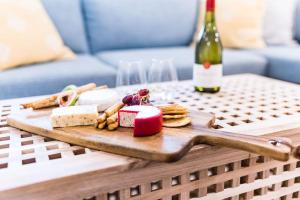 a wooden cutting board with food and a bottle of wine at Blairgowrie Whitesands - stay 3 nights for FREE WINE in Blairgowrie
