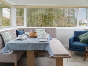 a dining room with a table and chairs and windows at Tweedford Cottage-uk41063 in Drummelzier