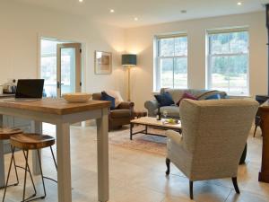 a living room with a table and a couch at Tweedford Cottage-uk41063 in Drummelzier
