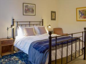 1 dormitorio con 1 cama con sábanas azules y blancas en Tweedford Cottage-uk41063 en Drummelzier