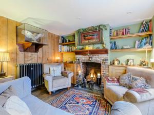 a living room with a couch and a fireplace at Anchor Light Cottage in Faversham