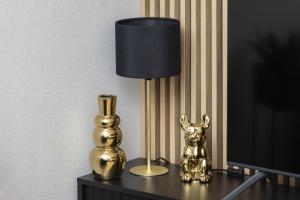 a gold lamp sitting on a table next to a vase at Apartments Beaufort Estate by Renters in Gdynia