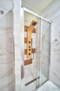 La salle de bains est pourvue d'une douche en verre et d'un objet en bois. dans l'établissement Apartament Willa Ogrodowa 18, à Polanica-Zdrój