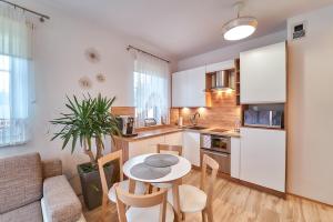a kitchen with a table and chairs in a room at Apartament Willa Ogrodowa 18 in Polanica-Zdrój