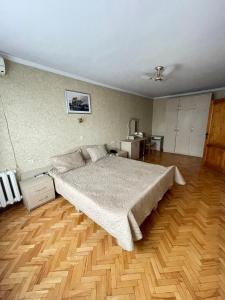 um quarto com uma cama grande e piso em madeira em Zarea Hotel em Chisinau