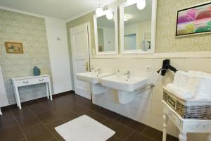 a bathroom with two sinks and a mirror at Ferienhaus Margret in Winterberg