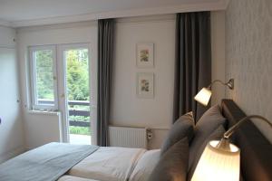 1 dormitorio con 1 cama con lámpara y ventana en Ferienhaus Margret en Winterberg