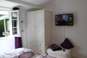 a bedroom with a white cabinet and a tv on the wall at Chalet Heide in Winterberg