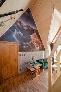 d'un salon avec une table et une peinture murale. dans l'établissement Reglove luksusowe apartamenty, à Zakopane