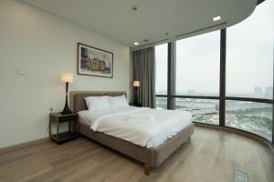 1 dormitorio con 1 cama grande y ventanas grandes en Landmark 81 Vinhomes Central Park Luxury Apartment, en Ho Chi Minh