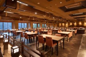 - une salle à manger avec des tables, des chaises et des fenêtres dans l'établissement Yukyo no Hibiki Yusai, à Minamioguni